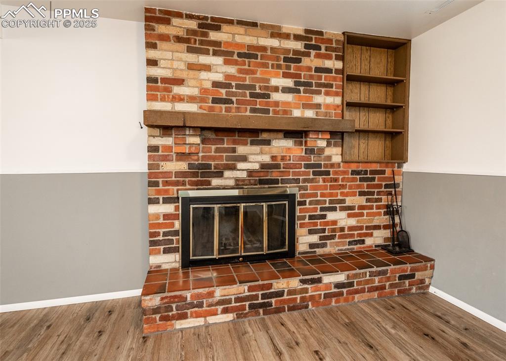 Image 16 of 22: Brick wood burning fireplace in basement