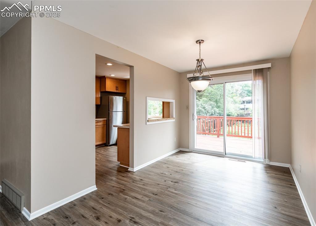 Image 6 of 22: Unfurnished dining area featuring dark wood-style flooring and recessed lig