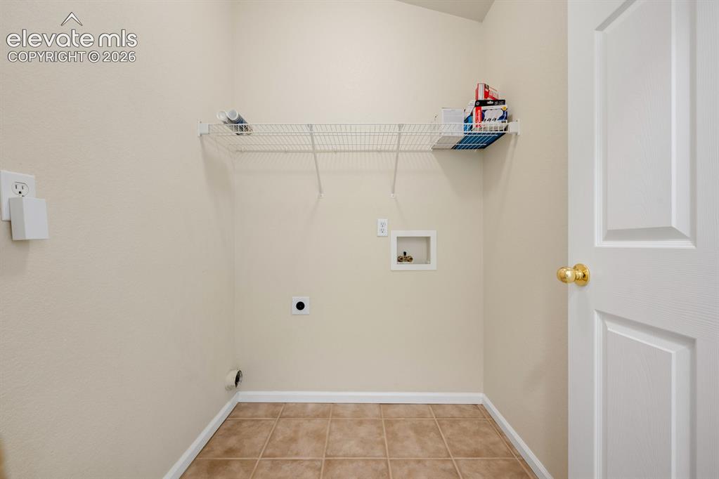 Image 14 of 33: Utility space featuring ceramic tile flooring, wire shelving, and dedicated