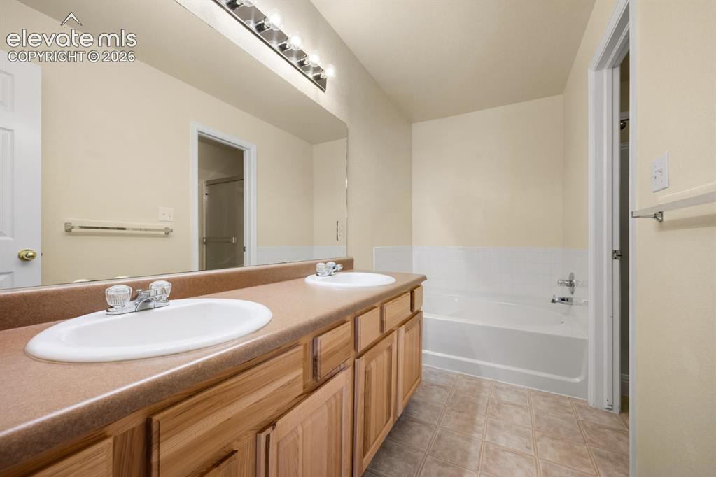Image 17 of 33: Dual-sink vanity with a solid-surface countertop, full-width wall mirror, w