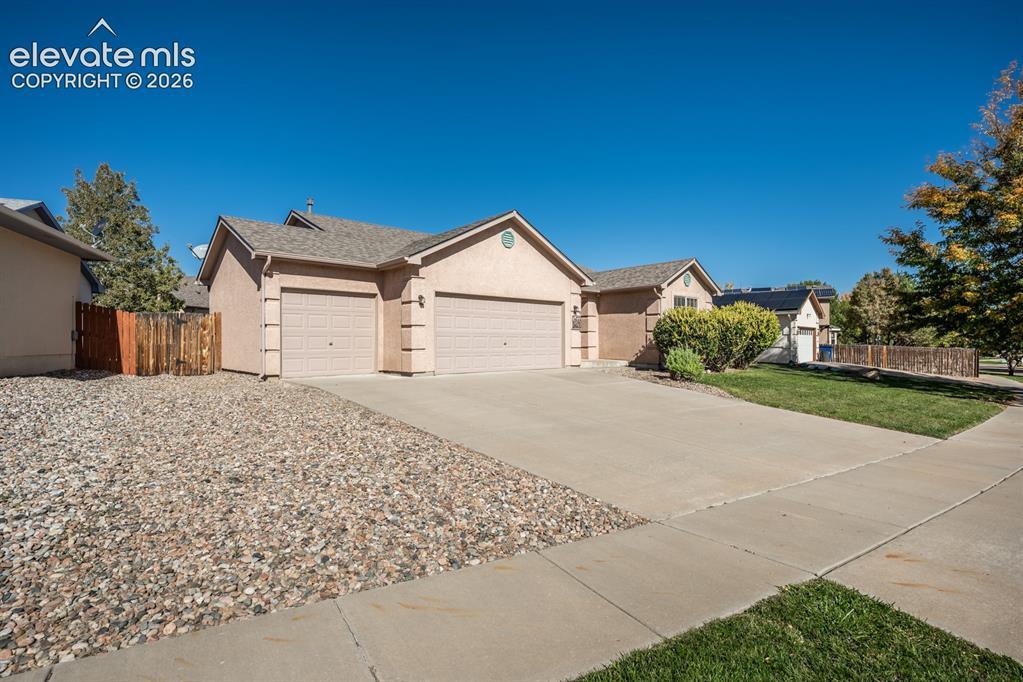 Image 2 of 33: Single-story residence featuring a stucco exterior, an attached three-car g