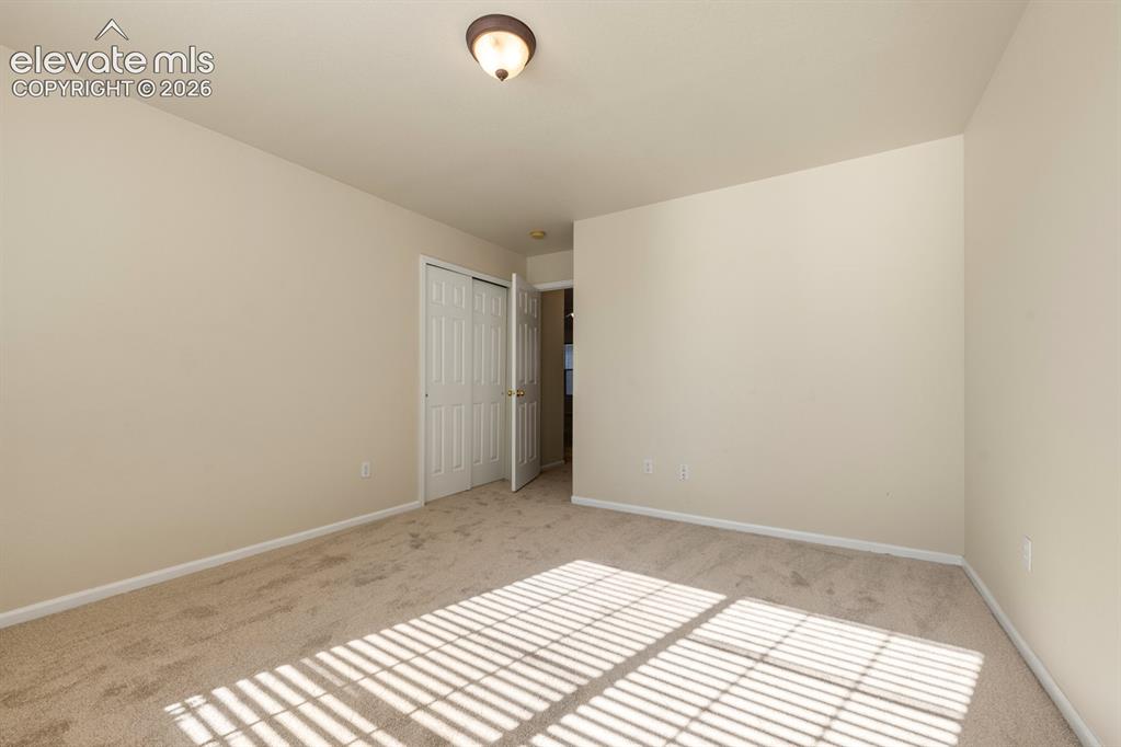 Image 21 of 33: Room featuring neutral-toned carpeting, off-white wall finishes, and a bifo