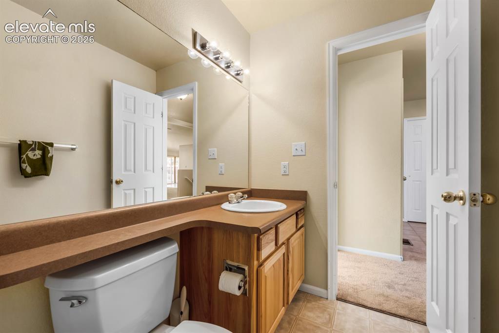 Image 23 of 33: Bathroom featuring a wood vanity with integrated countertop, inset sink, fu