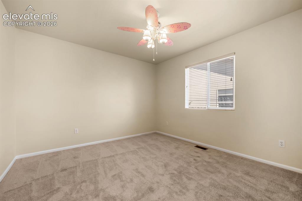 Image 24 of 33: Neutral-toned interior room featuring wall-to-wall carpeting, a multi-blade
