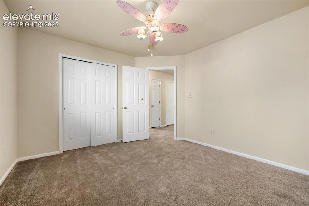 Image 25 of 33: Neutral-toned walls, wall-to-wall carpeting, and sliding-panel closet doors
