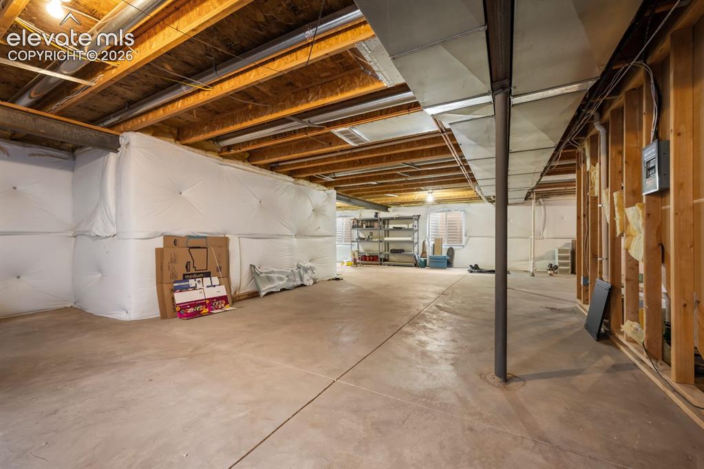 Image 26 of 33: Unfinished basement featuring an exposed timber joist ceiling, concrete flo