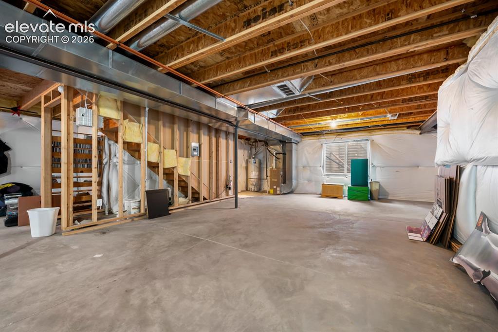 Image 27 of 33: Unfinished lower level featuring exposed wood joist ceilings, concrete floo