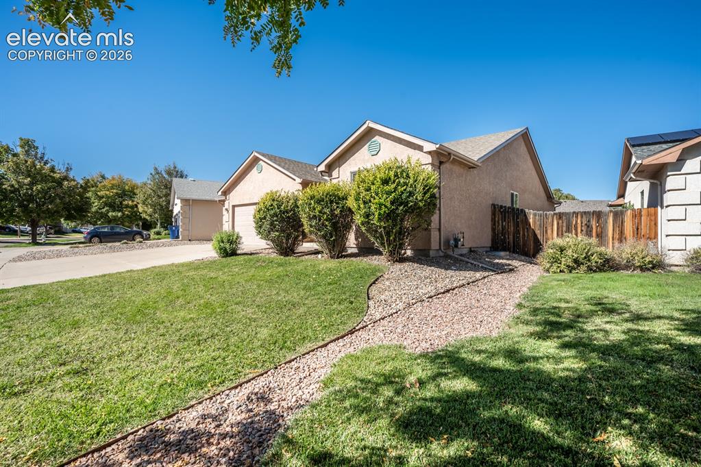 Image 3 of 33: Single-story stucco exterior featuring a concrete driveway, attached garage
