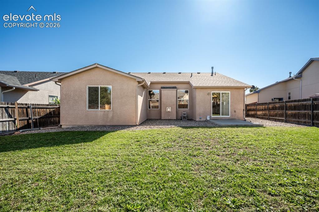 Image 32 of 33: Stucco exterior featuring a composition shingle roof, rear concrete patio, 