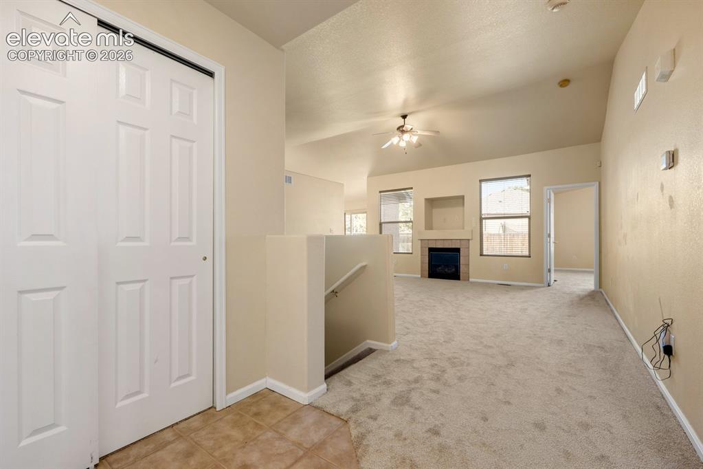 Image 4 of 33: Interior space featuring vaulted ceilings, a fireplace with a neutral tile 