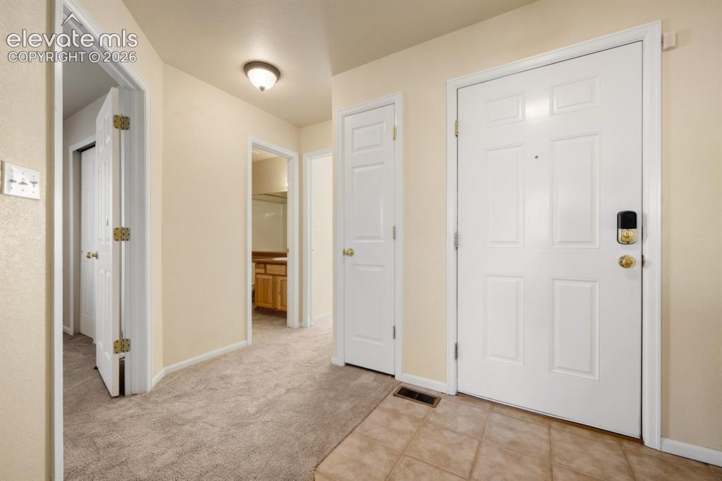 Image 5 of 33: Entryway featuring tile flooring, neutral wall-to-wall carpeting, white six
