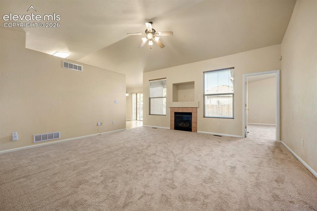 Image 6 of 33: Vaulted ceilings, fireplace with tile surround, built-in media niche, and c