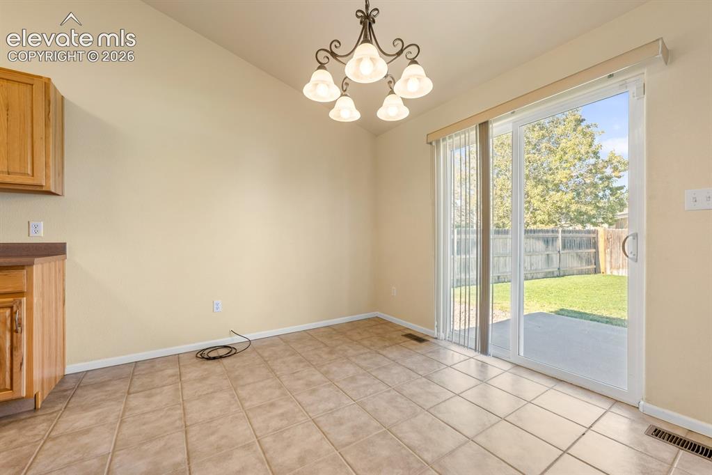 Image 8 of 33: Ceramic tile flooring, five-light traditional chandelier, sliding glass doo