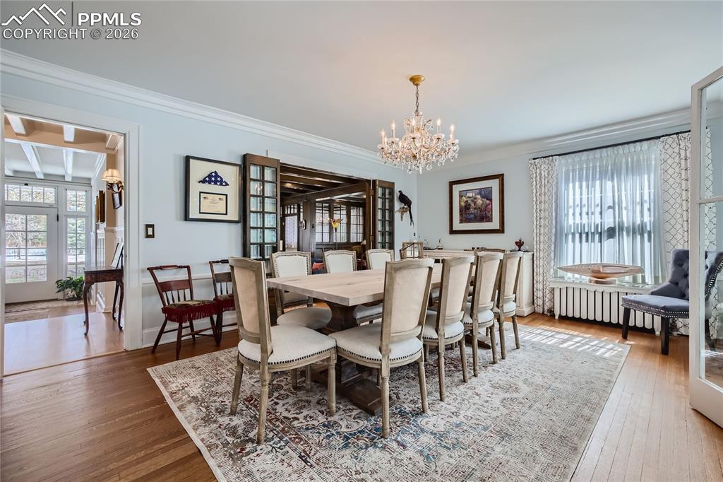 Image 15 of 49: Dining room featuring hardwood / wood-style floors, ornamental molding, and