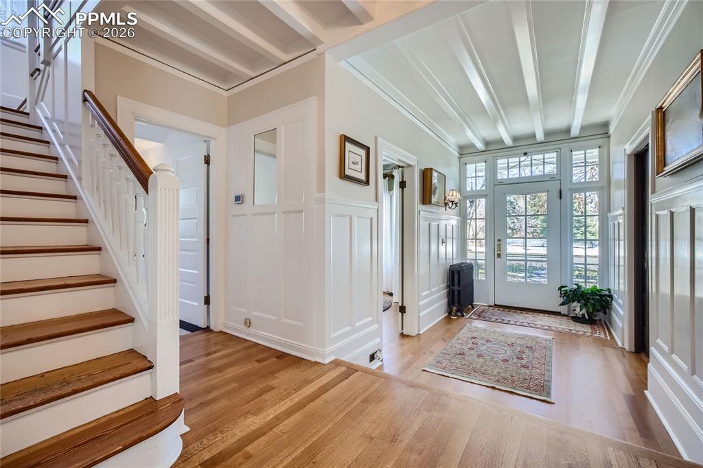 Image 16 of 49: Foyer featuring beam ceiling, light wood flooring, and crown molding