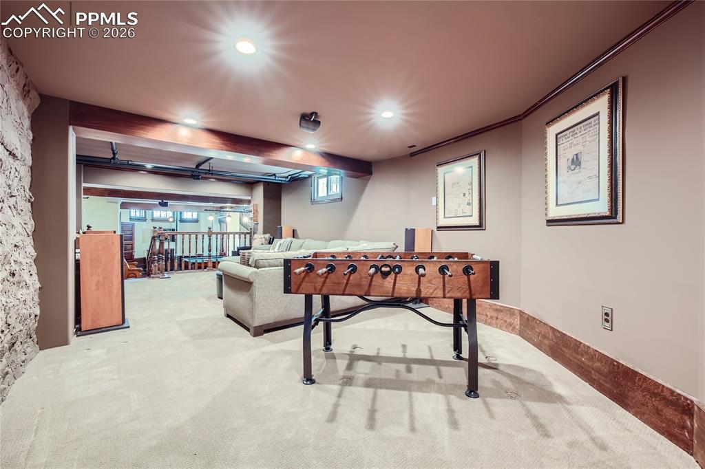 Image 26 of 49: Recreation room featuring crown molding, beamed ceiling, a wealth of natura