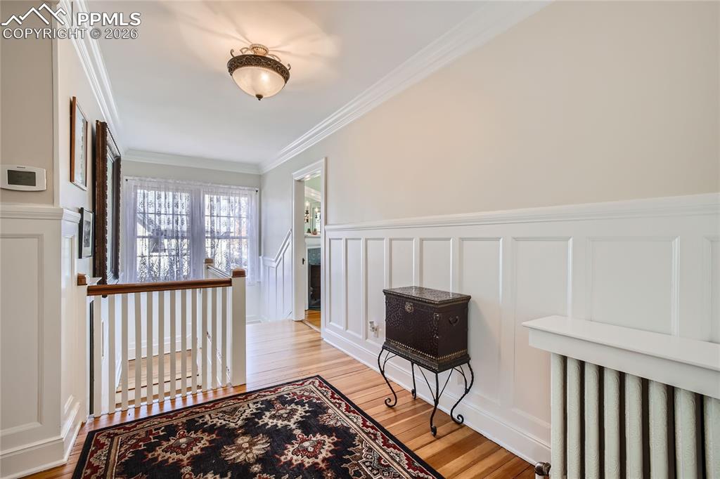 Image 28 of 49: Hallway featuring ornamental molding and light hardwood floors