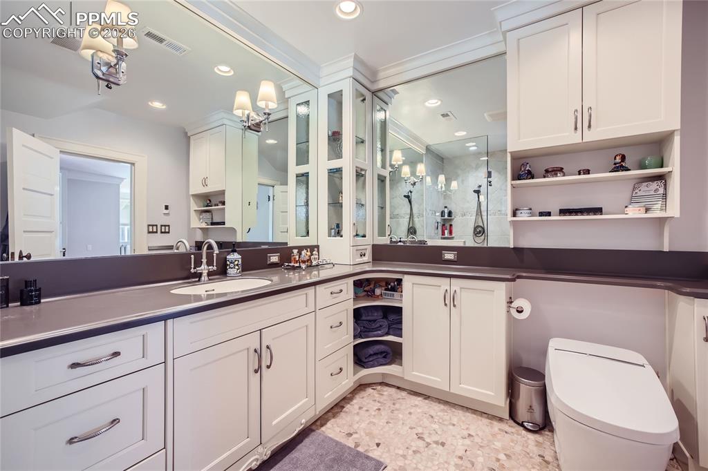 Image 31 of 49: Bathroom with a toilet, vanity with extensive cabinet space, and tile floor