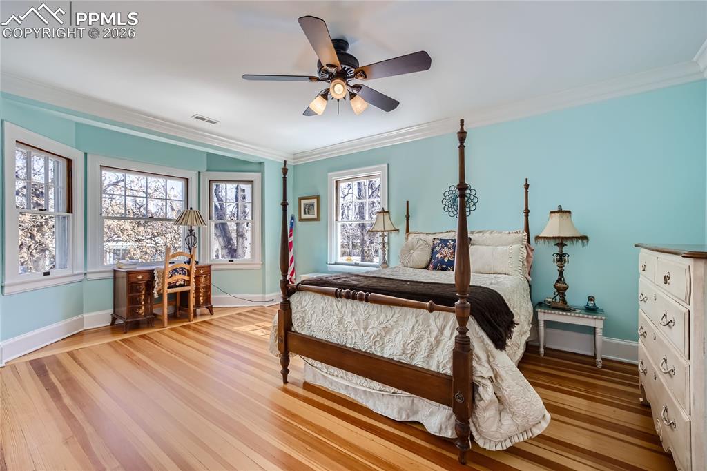 Image 36 of 49: Bedroom featuring ceiling fan, ornamental molding, and light hardwood floor