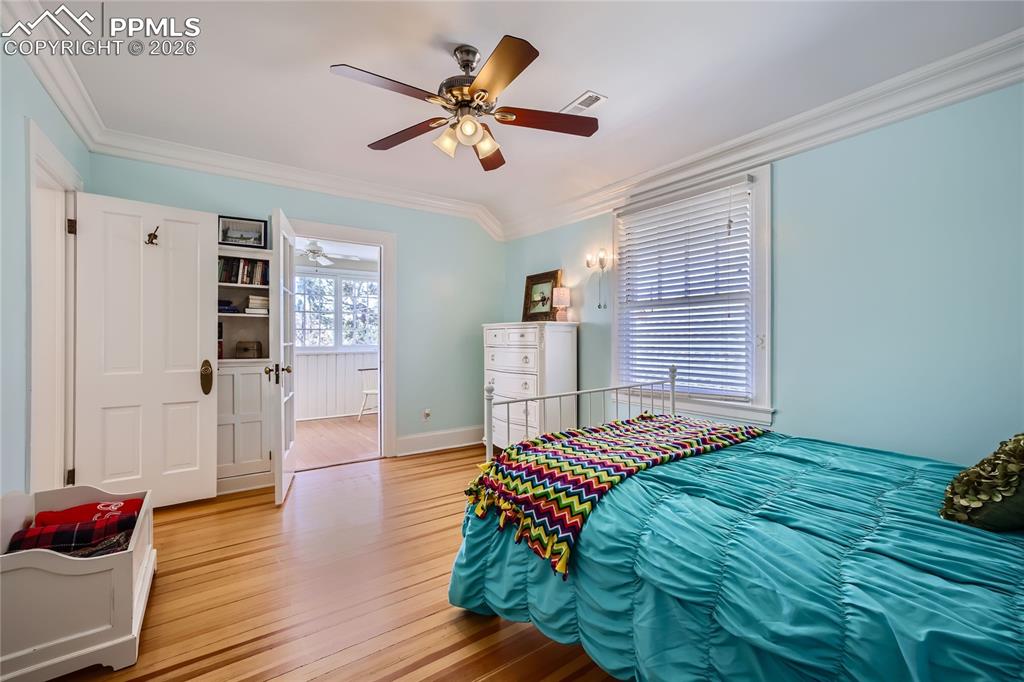 Image 38 of 49: Bedroom featuring crown molding, light hardwood flooring, and ceiling fan