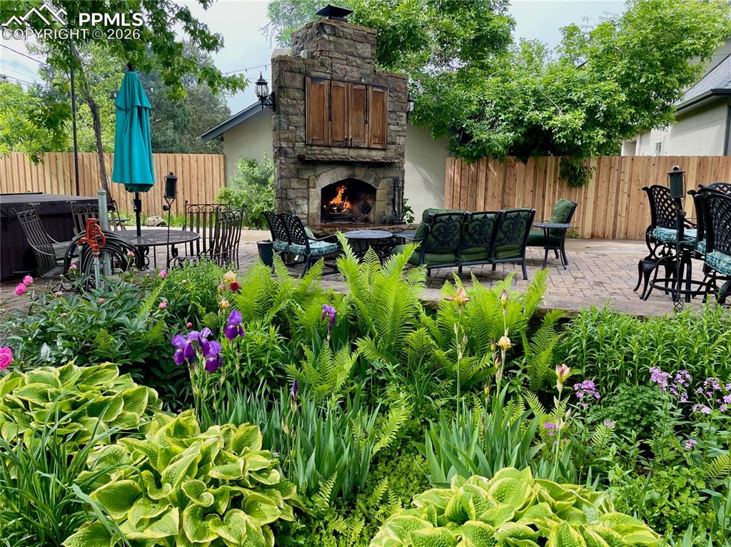Image 5 of 49: View of yard featuring a patio and an outdoor stone fireplace