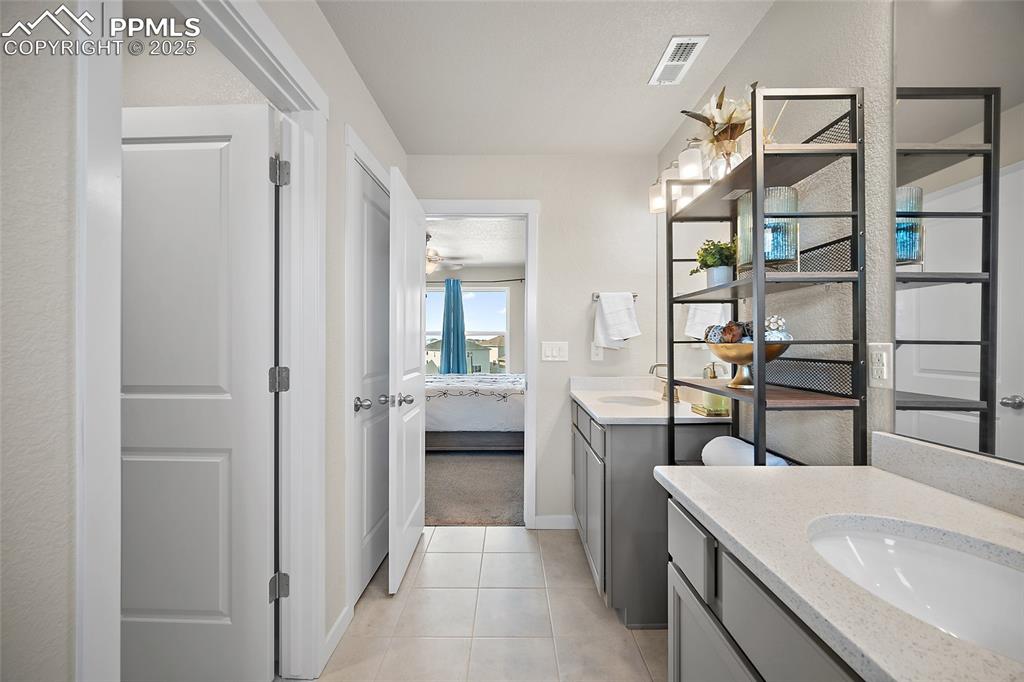 Image 10 of 41: Full bathroom featuring ensuite bath, two vanities, and tile patterned floo