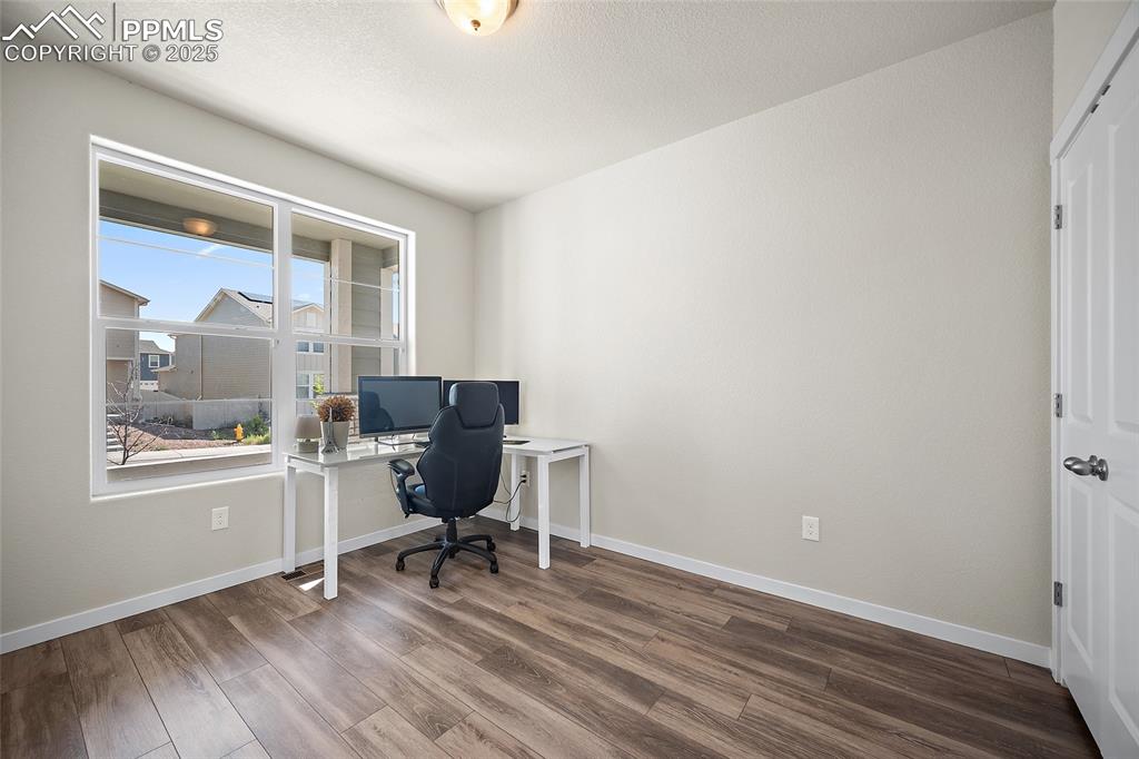 Image 17 of 41: Home office with wood finished floors and baseboards