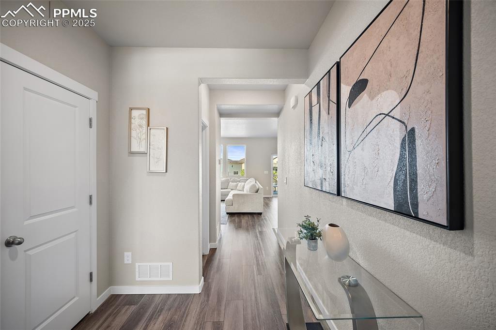 Image 2 of 41: Hall featuring dark wood finished floors and baseboards