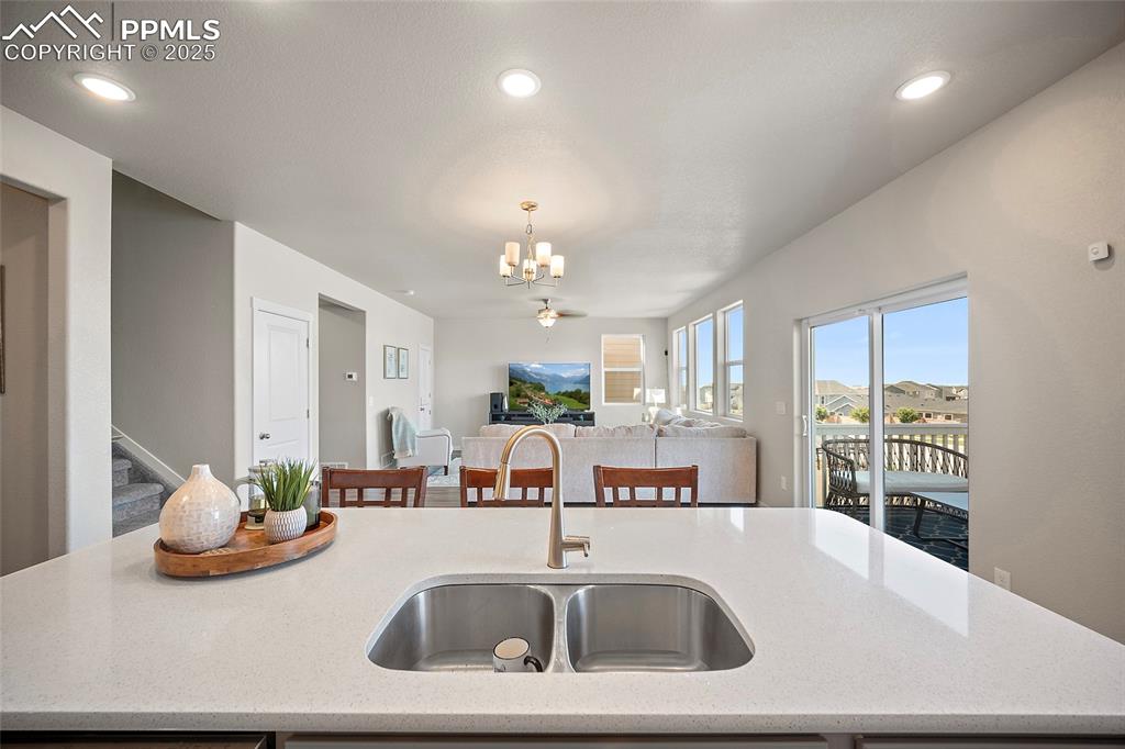 Image 22 of 41: Kitchen with a chandelier, open floor plan, hanging light fixtures, light s