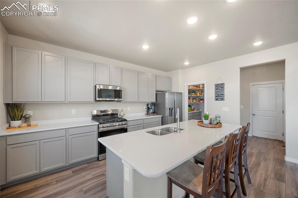 Image 23 of 41: Kitchen with appliances with stainless steel finishes, gray cabinets, a bre