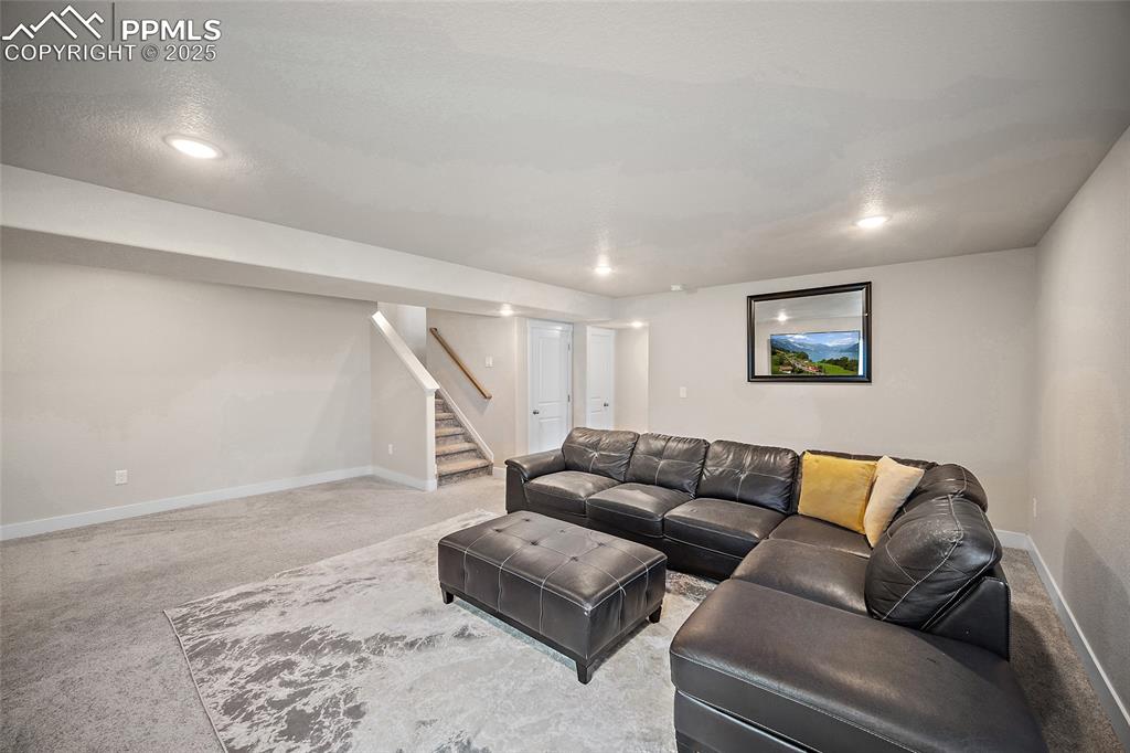 Image 25 of 41: Carpeted living area featuring stairs and recessed lighting
