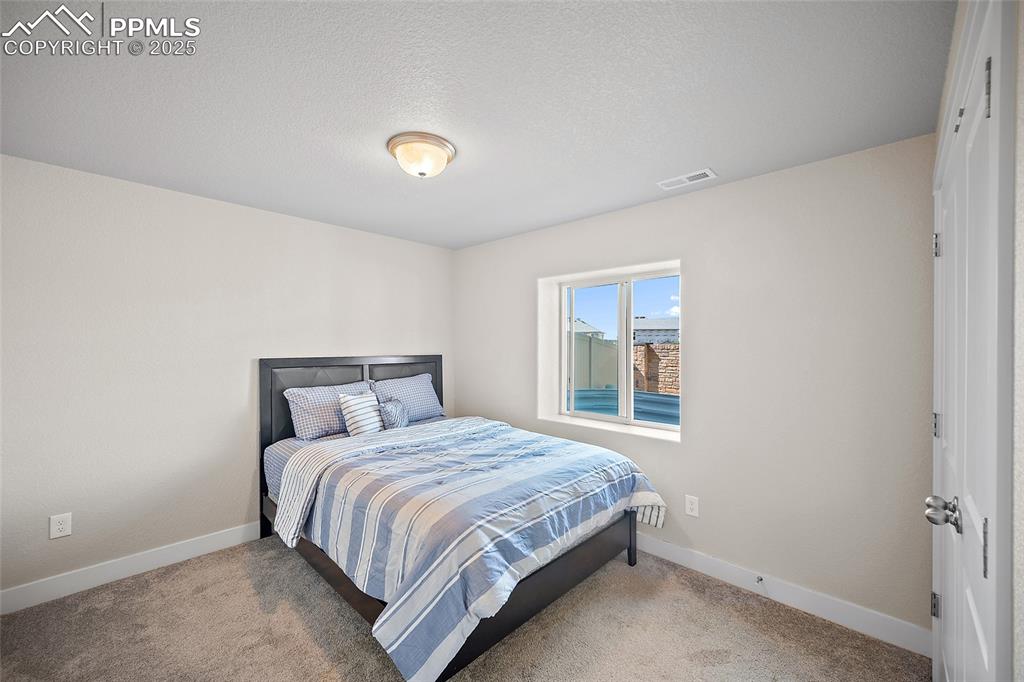 Image 26 of 41: Carpeted bedroom featuring baseboards and a textured ceiling