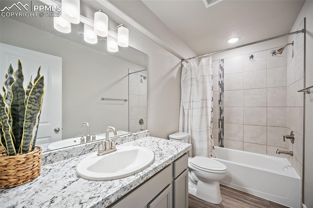 Image 27 of 41: Full bathroom with vanity, shower / bath combo, and wood finished floors