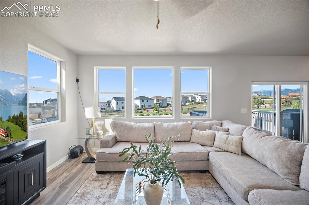Image 4 of 41: Living area with a textured ceiling, a residential view, and light wood-sty