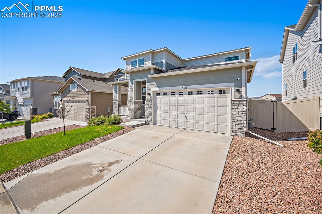 Image 40 of 41: View of front of home with stone siding, driveway, and a residential view