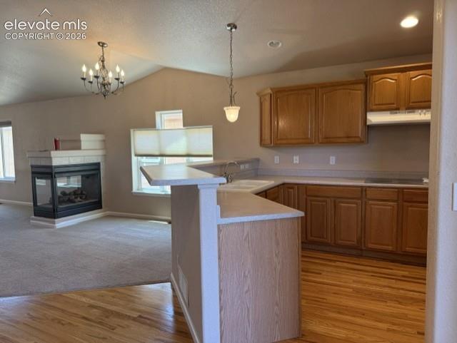 Image 10 of 24: Kitchen featuring wood-finish flooring, wood cabinetry, a built-in cooktop,