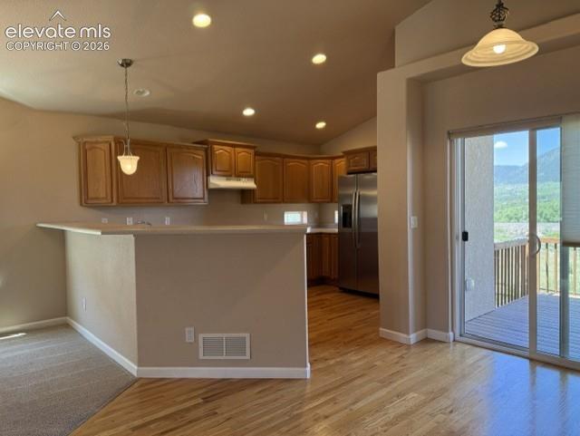 Image 11 of 24: Kitchen featuring warm wood cabinetry, stainless steel appliances, and a br