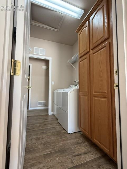 Image 12 of 24: Dedicated utility space featuring wood-finish flooring, a built-in storage 