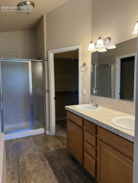 Image 14 of 24: Bathroom featuring wood-finish tile flooring, a shower with a sliding frost