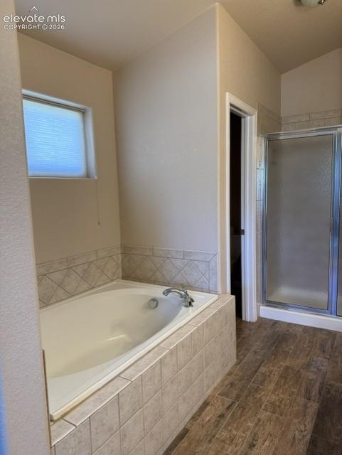 Image 15 of 24: Bathroom featuring a built-in tub with chrome fixtures, surrounded by neutr