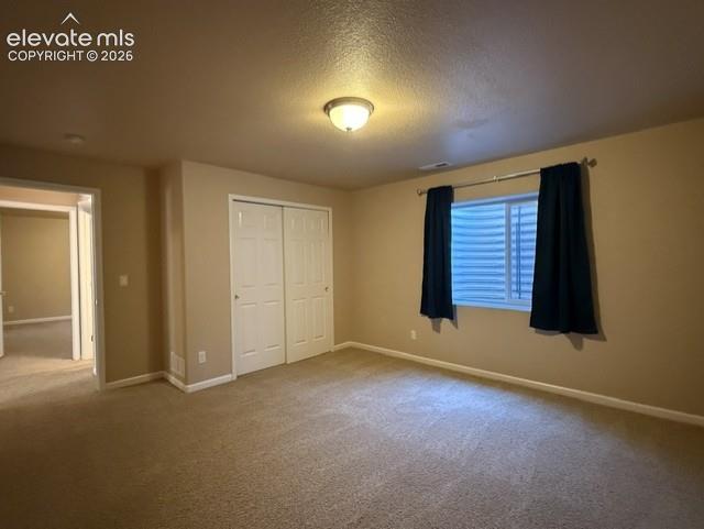 Image 20 of 24: Carpeted room featuring a ceiling-mounted light fixture, louvered window wi