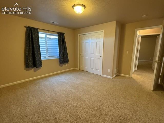Image 21 of 24: Carpeted room featuring a window with an egress well, a built-in closet wit