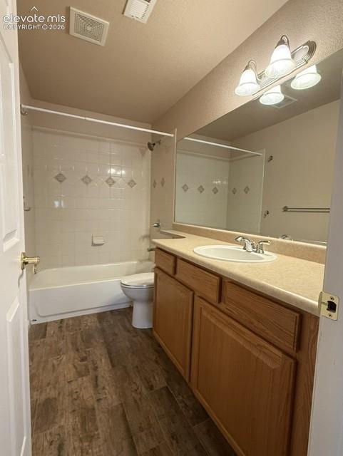 Image 22 of 24: Bathroom featuring a wood-finish vanity with a built-in sink, a full-width 