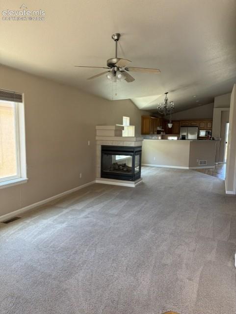 Image 6 of 24: Open-concept living space featuring vaulted ceilings, a ceiling fan, and a 