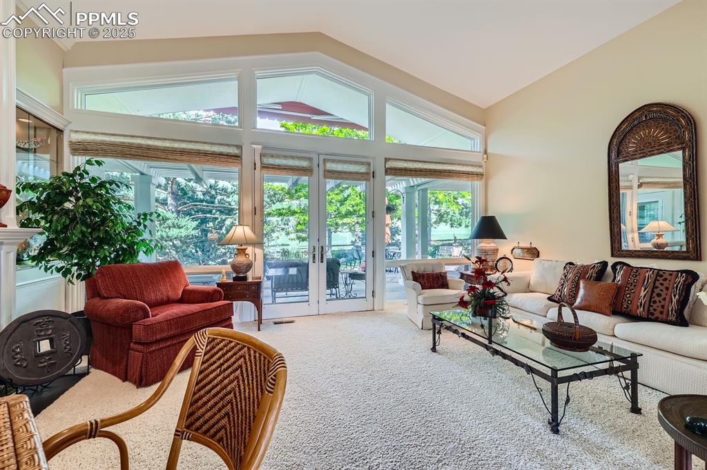 Image 11 of 49: Walls of windows bring nature in this light and bright living room