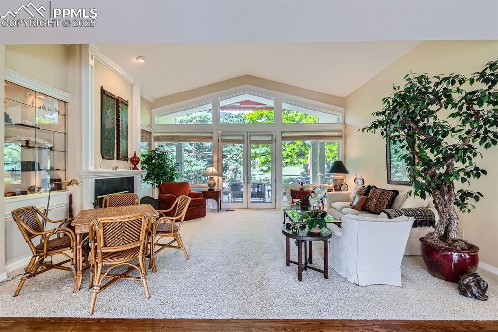 Image 12 of 49: Living area with lofted ceiling and french doors