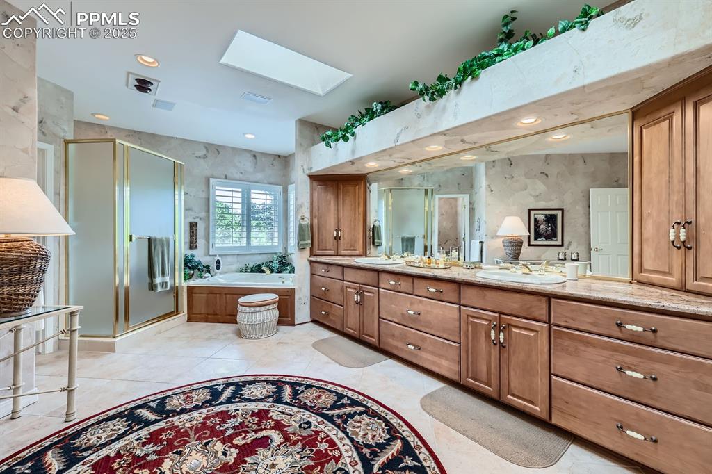Image 16 of 49: Jetted tub and custom shutters in this spa retreat very private bathroom