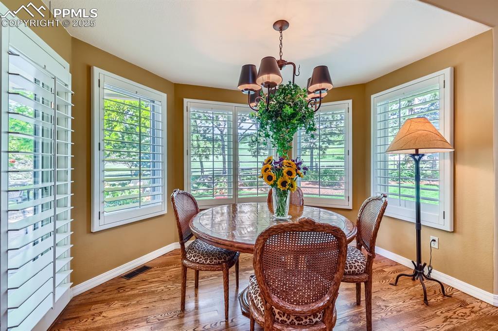 Image 22 of 49: hardwood flooring throughout the main level in this sunlit home