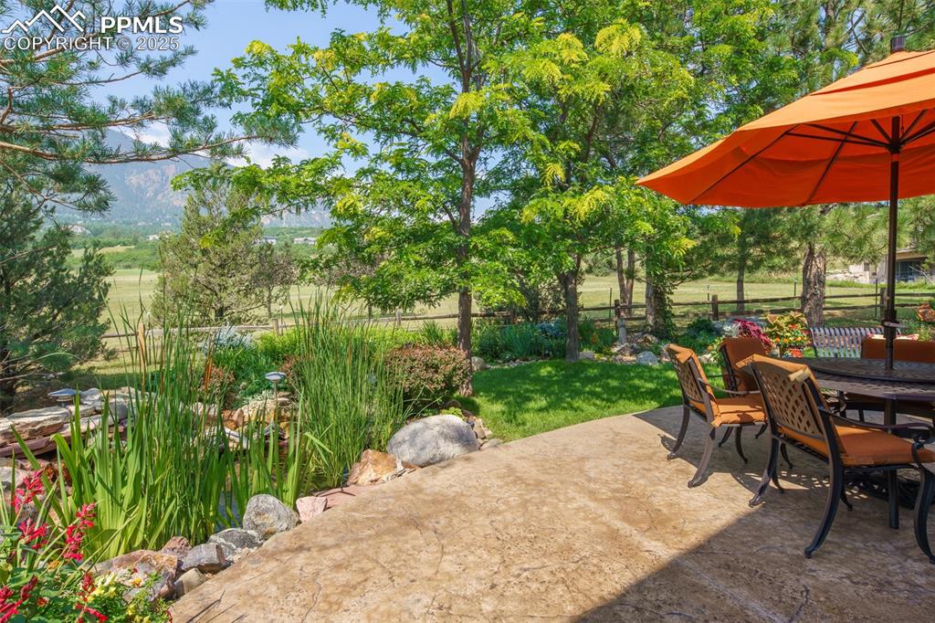Image 28 of 49: Expansive patio with unobstructed views of Cheyenne Mountain and bordering
