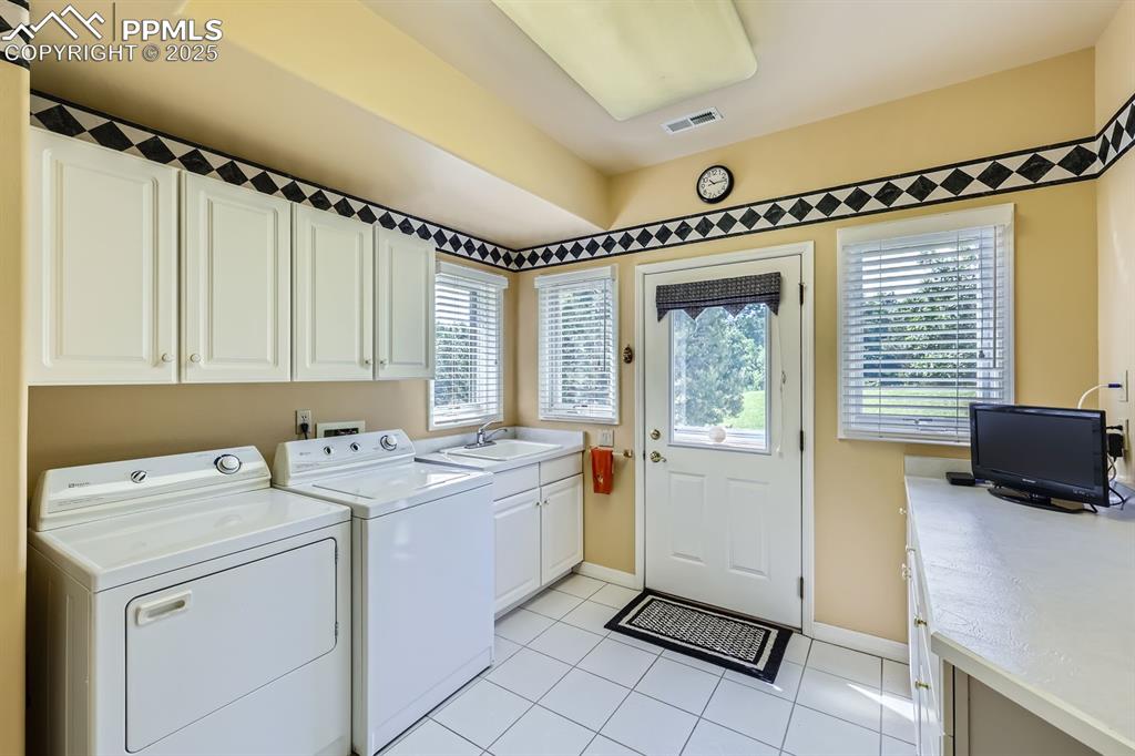 Image 32 of 49: Laundry room that opens onto the side yard. Large enough for a hobby room,